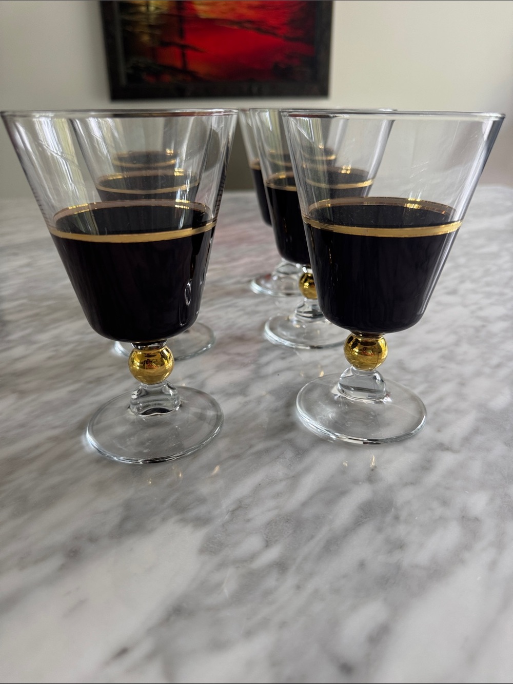 Set of six stemmed black with gold trim glasses.